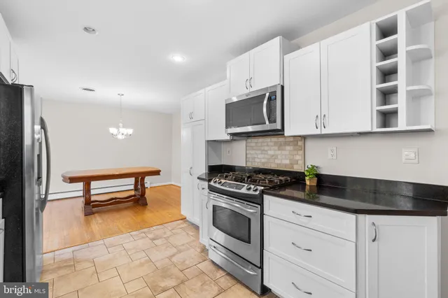 a kitchen with granite countertop white cabinets and stainless steel appliances