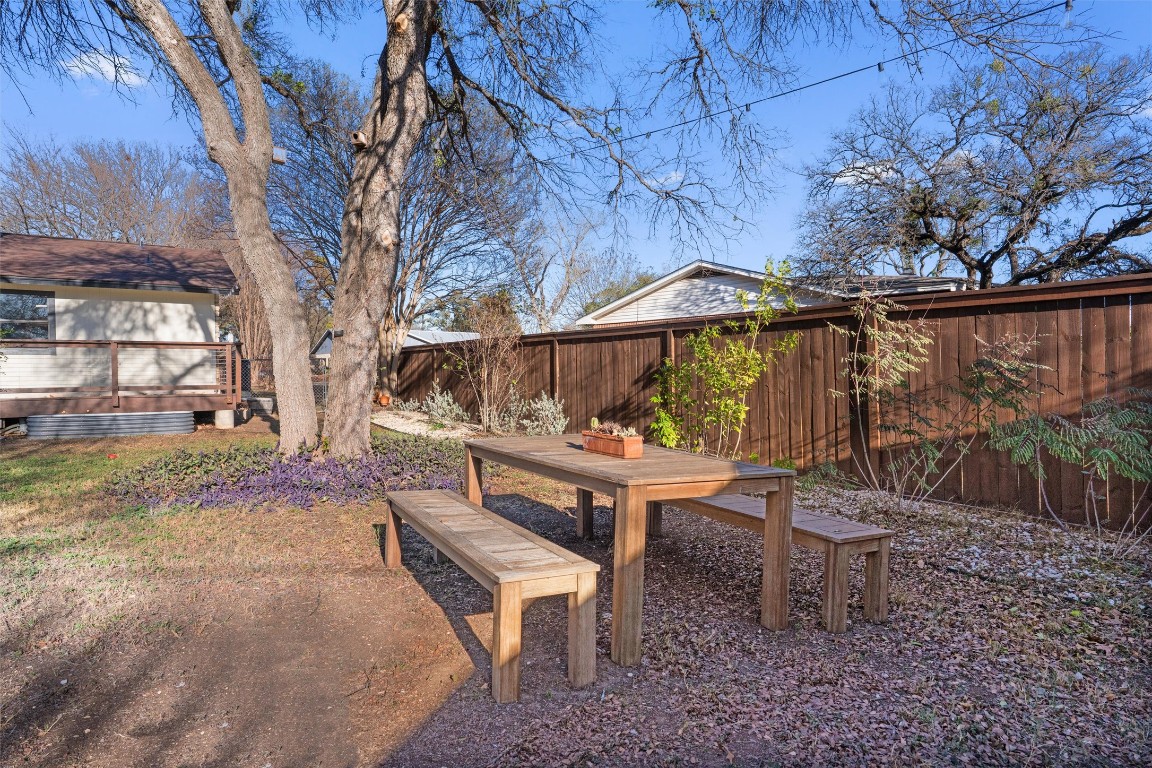 1204 Dunman Drive Georgetown, TX 78628 - Photo 33 of 40 a backyard of a house with table and chairs under an umbrella