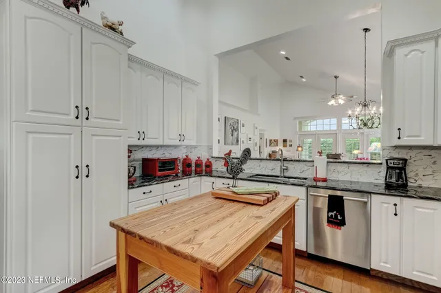a kitchen with stainless steel appliances granite countertop a stove and cabinets