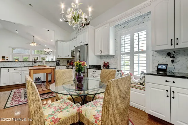 a view of a dining room with furniture a chandelier and wooden floor