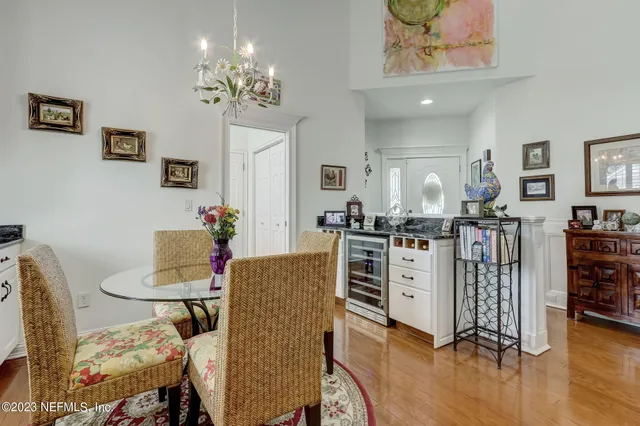 a dining room with furniture a rug a potted plant and wooden floor