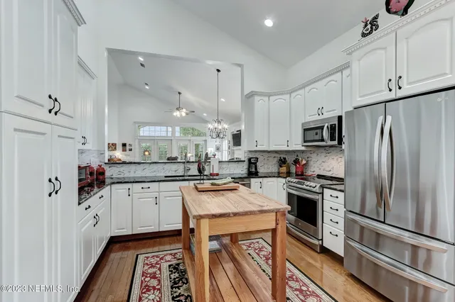 a kitchen with granite countertop a sink appliances and cabinets