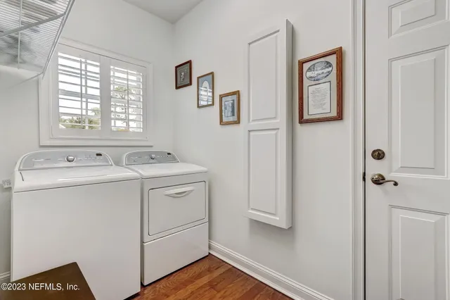a front view of a house with a yard and potted plants