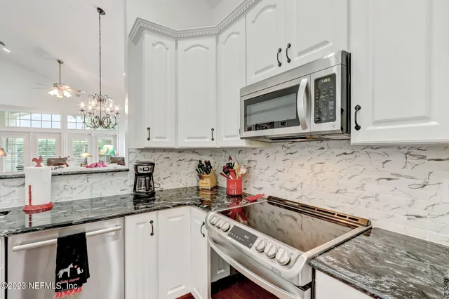 a kitchen with white cabinets and white appliances