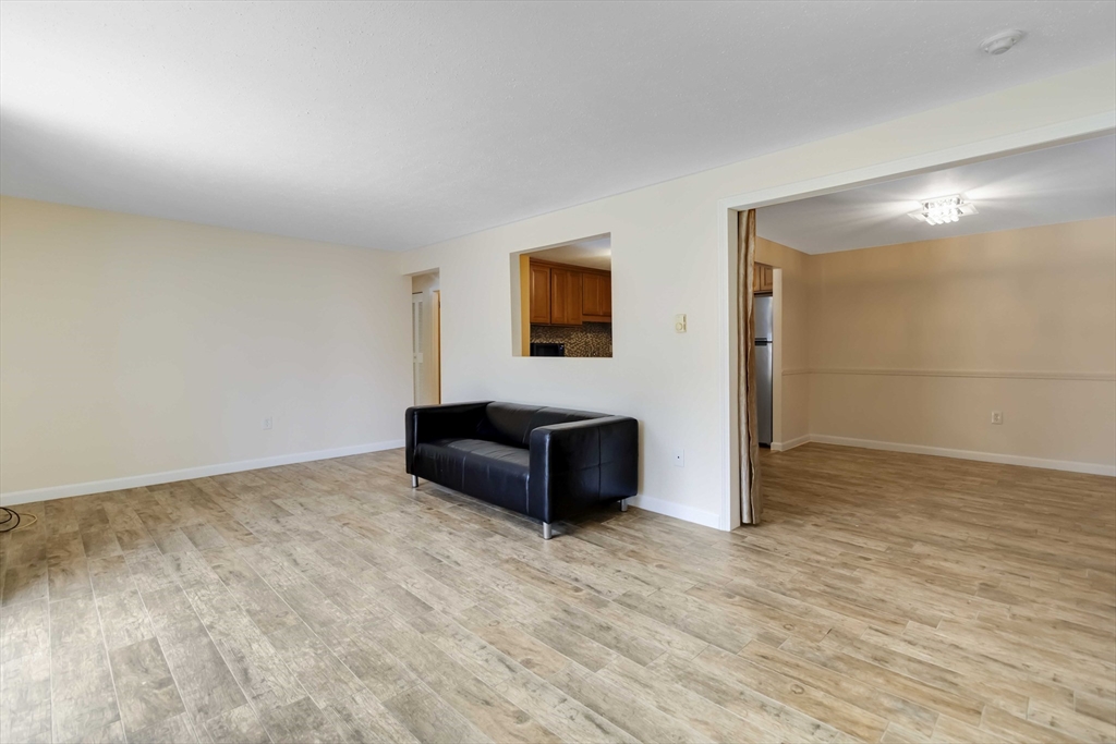388 Great Road, Unit B14 Acton, MA 01720 - Photo 15 of 24 a view of an empty room with wooden floor and a window