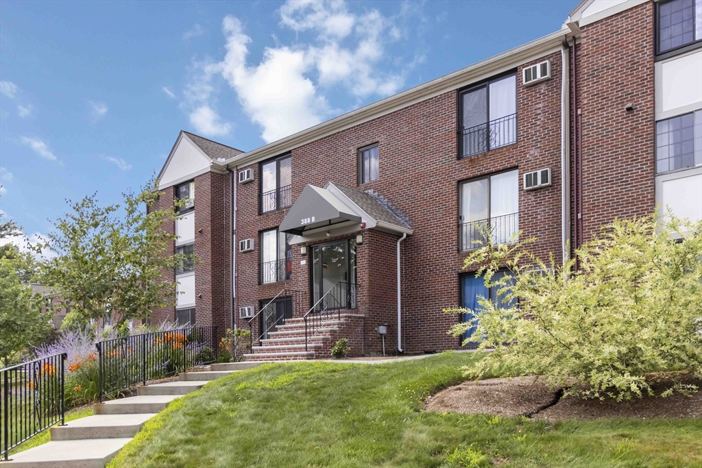 388 Great Road, Unit B14 Acton, MA 01720 - Photo 2 of 24 a front view of a house with a garden