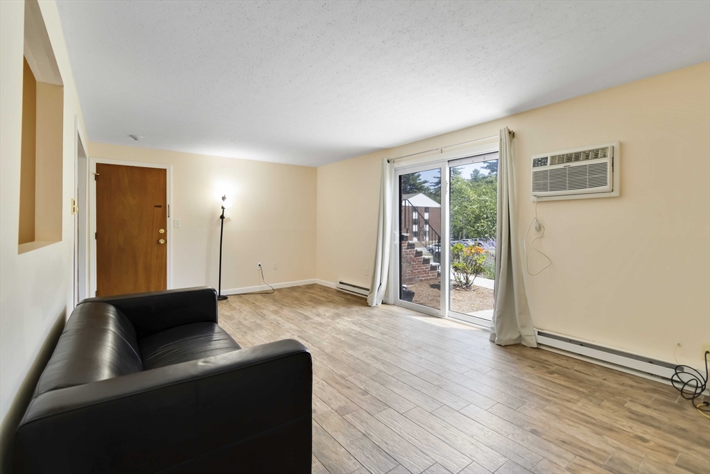 388 Great Road, Unit B14 Acton, MA 01720 - Photo 4 of 24 a living room with hardwood floor and a large window