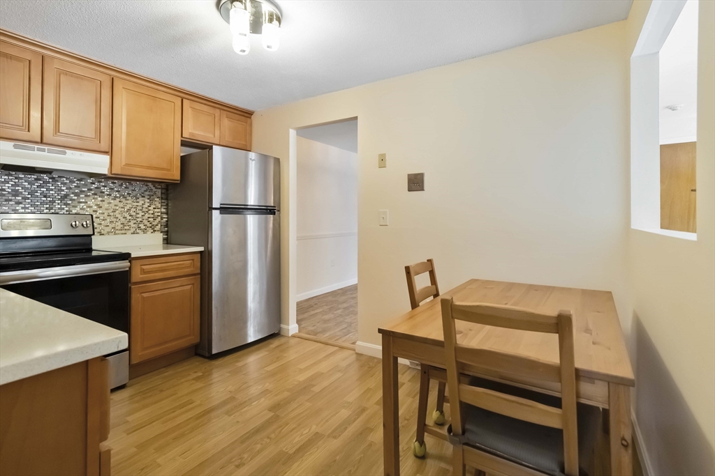 388 Great Road, Unit B14 Acton, MA 01720 - Photo 10 of 24 a kitchen with a refrigerator and wooden floor