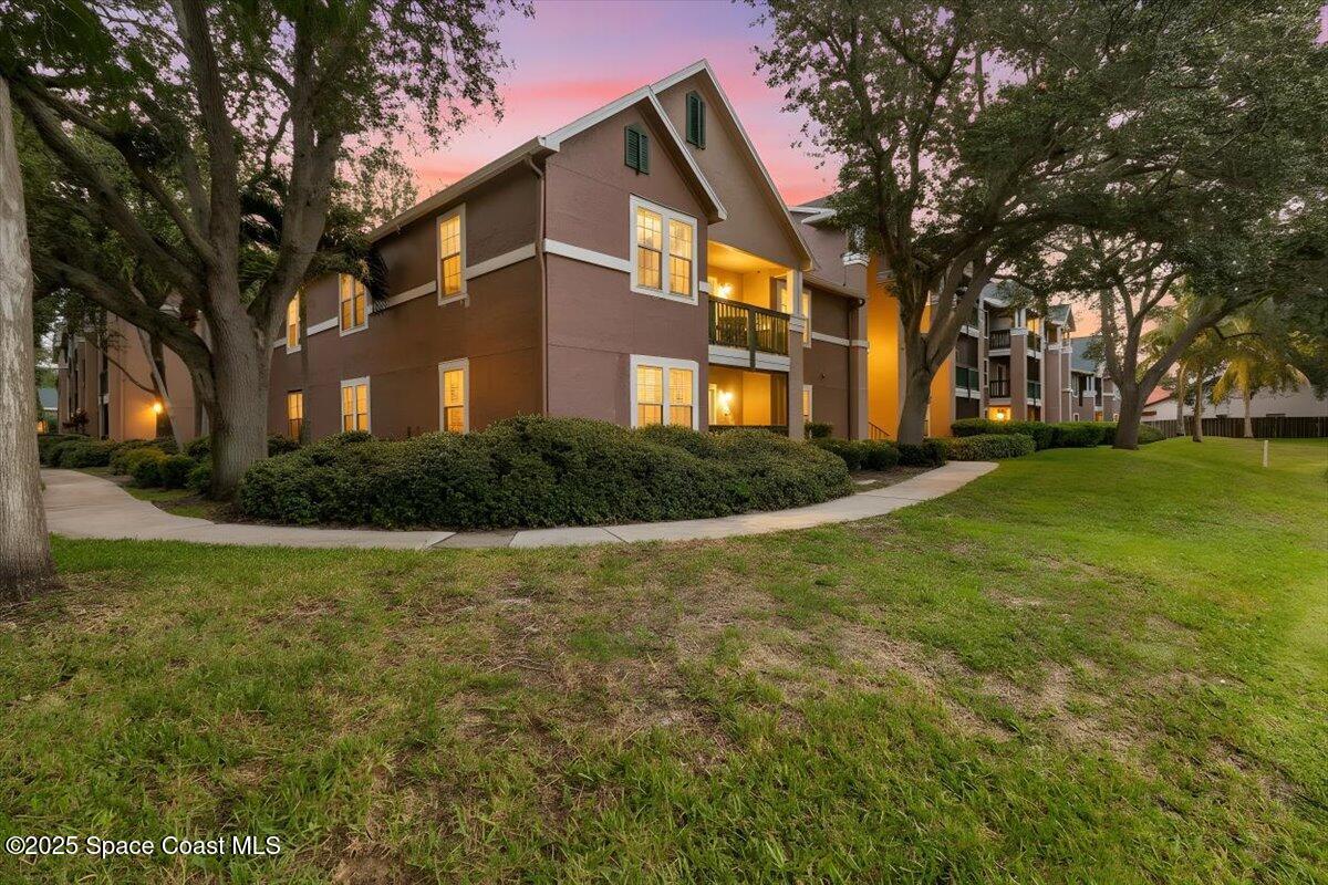 7667 North Wickham Road, Unit 118 Melbourne, FL 32940 - Photo 22 of 23 a front view of house with yard and green space