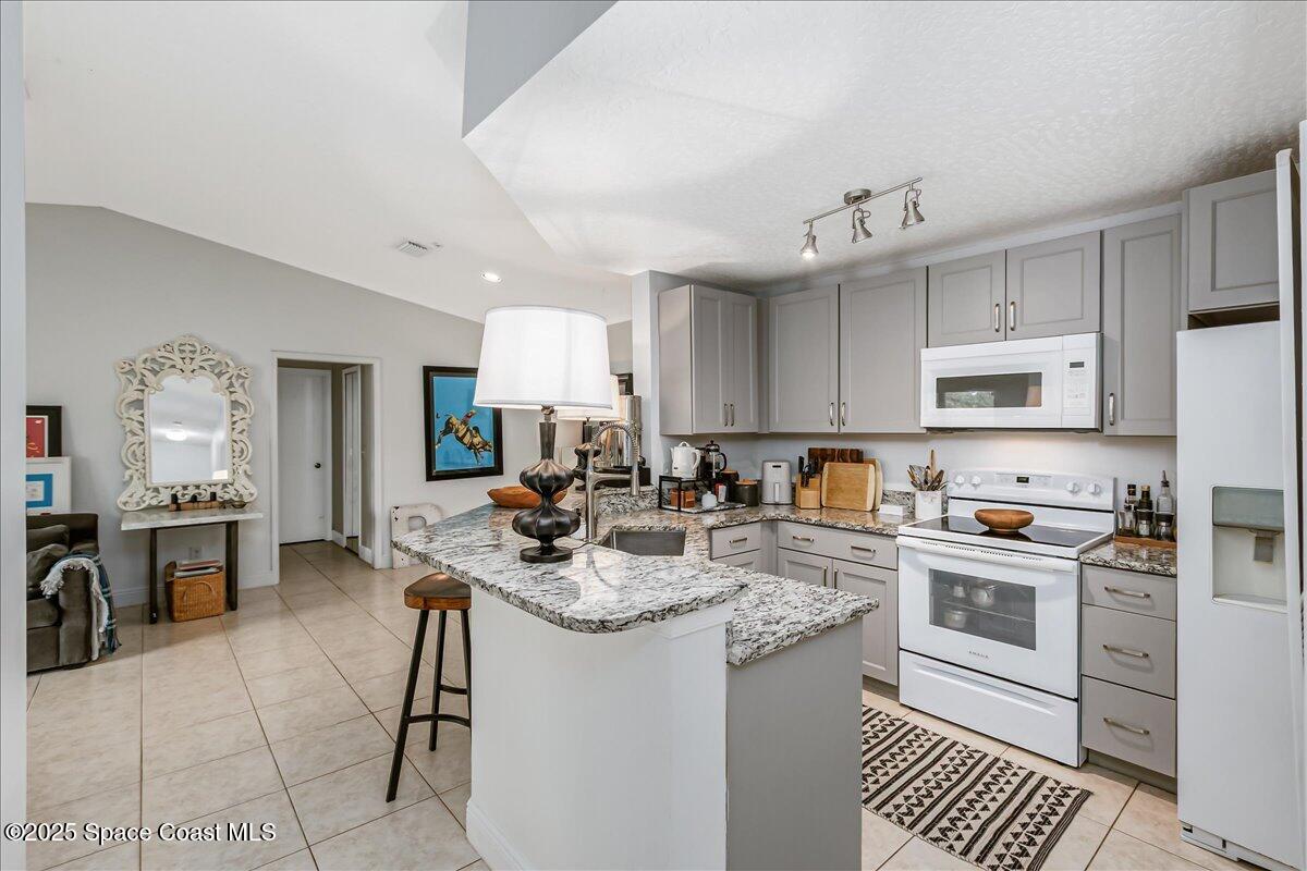 7667 North Wickham Road, Unit 118 Melbourne, FL 32940 - Photo 3 of 23 a kitchen with a sink a stove cabinets and refrigerator