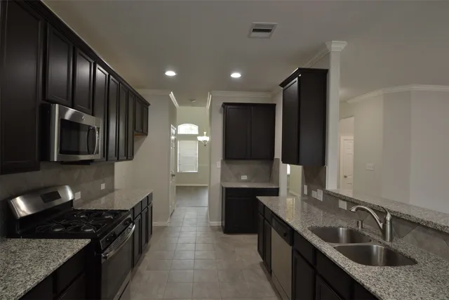 a kitchen with stainless steel appliances granite countertop a sink stove and refrigerator