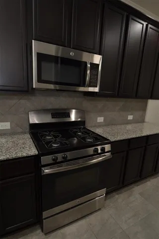 a kitchen with granite countertop stainless steel appliances and wooden cabinets