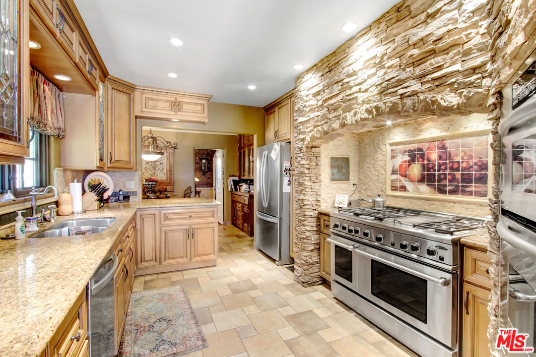 303 Armsley Square Ontario, CA 91762 - Photo 6 of 13 a large kitchen with stainless steel appliances granite countertop a stove and a sink