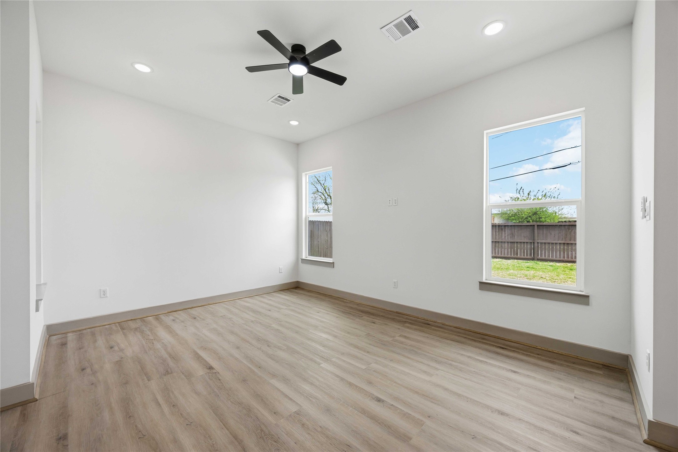 7555 Calhoun Road, Unit A/B Houston, TX 77033 - Photo 12 of 27 an empty room with wooden floor and windows