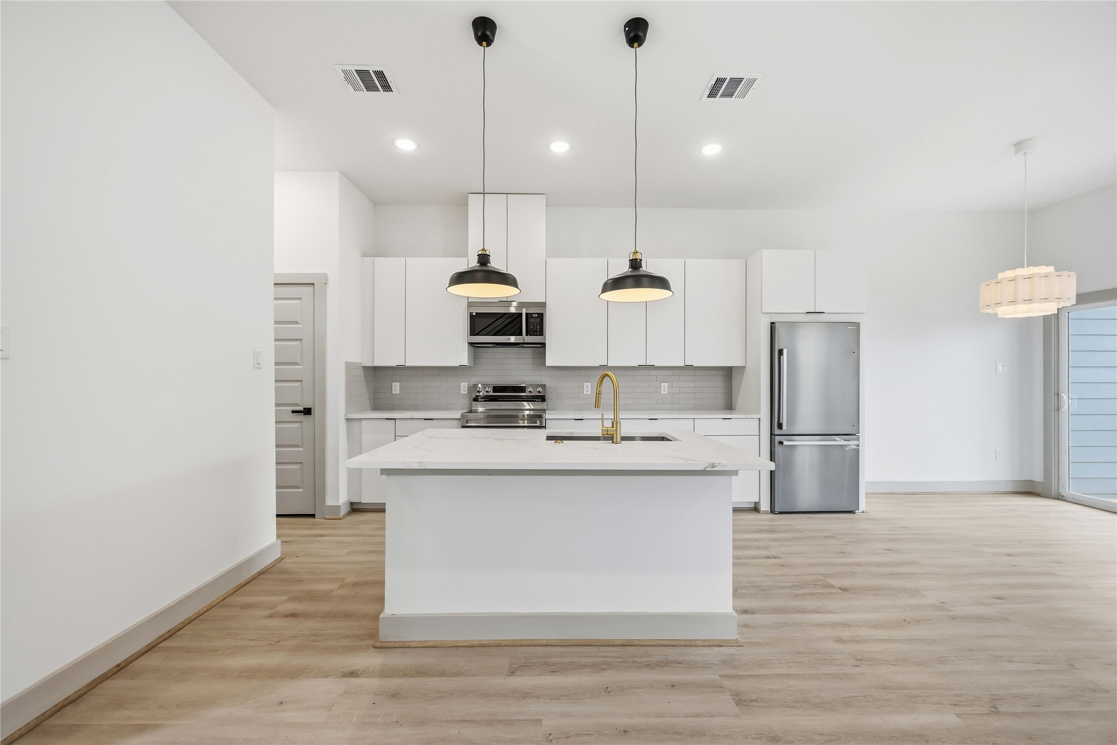 7555 Calhoun Road, Unit A/B Houston, TX 77033 - Photo 6 of 27 a large kitchen with stainless steel appliances kitchen island granite countertop a sink and a refrigerator