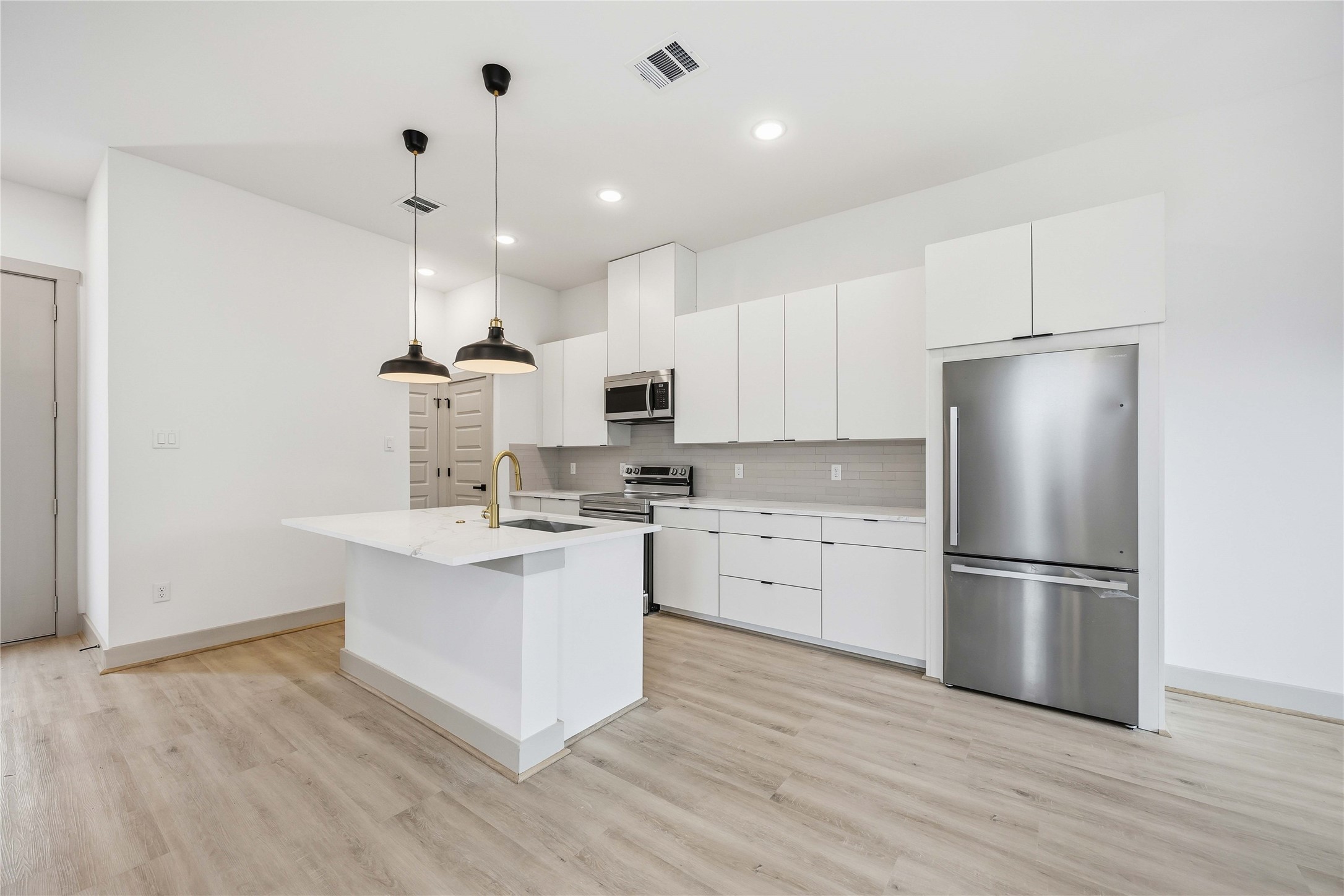 7555 Calhoun Road, Unit A/B Houston, TX 77033 - Photo 8 of 27 a kitchen with kitchen island white cabinets and stainless steel appliances