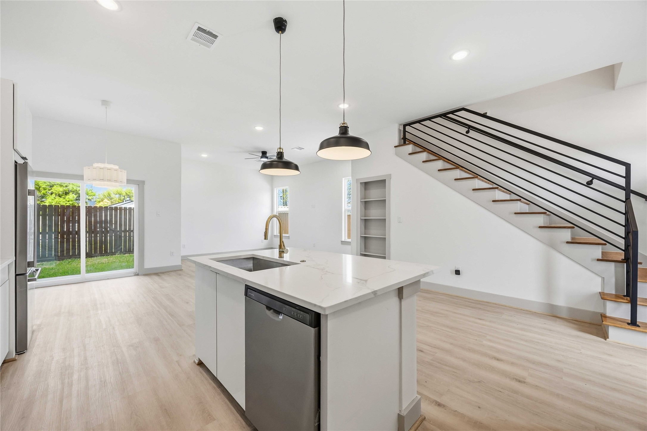 7555 Calhoun Road, Unit A/B Houston, TX 77033 - Photo 9 of 27 a kitchen with a sink a faucet a chandelier and wooden floor