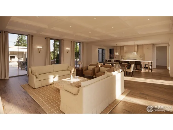 a living room with couches and kitchen view with wooden floor