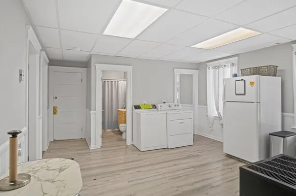 a room with a bed and a refrigerator