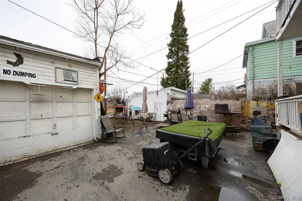 a backyard of a house with barbeque oven table and chairs