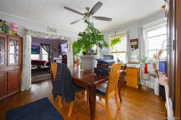 a dining room with furniture potted plants and wooden floor