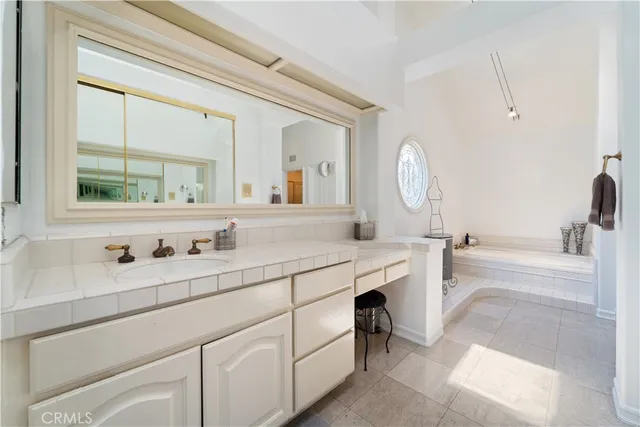 a bathroom with a tub sink and mirror