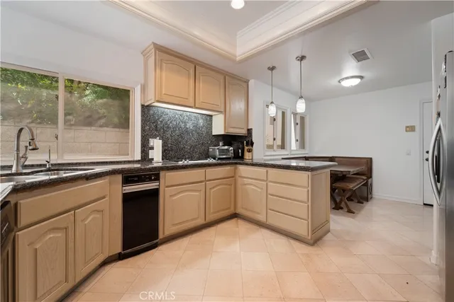 a kitchen with granite countertop a sink stove and refrigerator