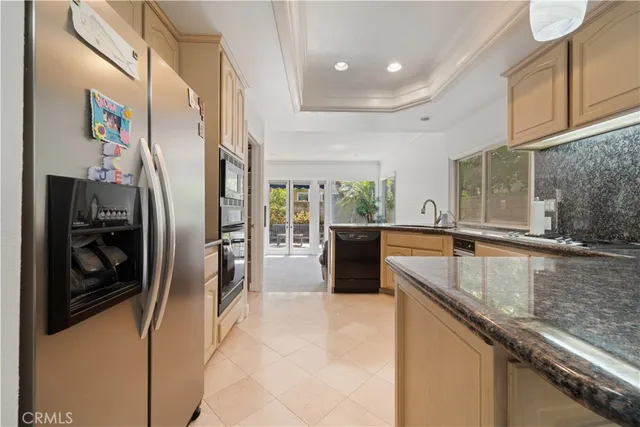 a kitchen with stainless steel appliances granite countertop a sink and a refrigerator