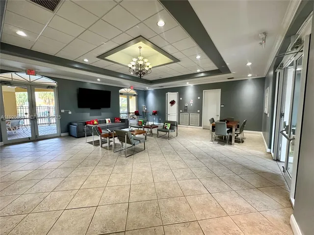 a living room with furniture a flat screen tv and a chandelier
