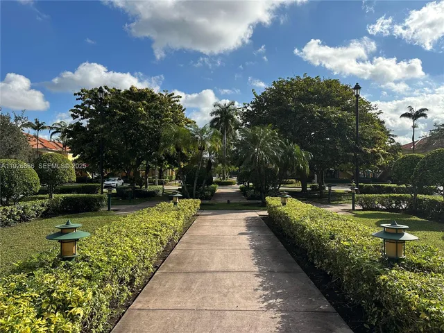 a front view of a house with a yard and potted plants