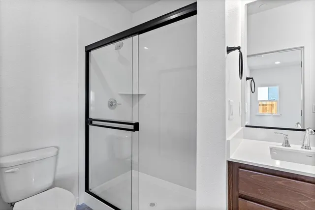 a bathroom with a shower a toilet and a sink