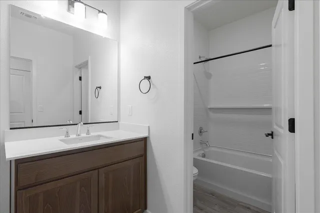 a bathroom with a granite countertop sink a mirror and a bathtub