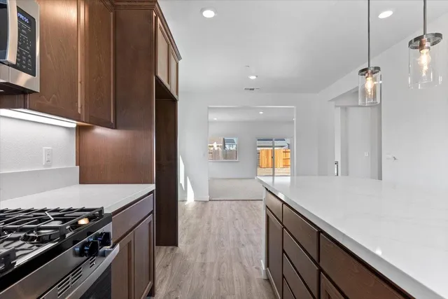 a kitchen with granite countertop a stove and a refrigerator