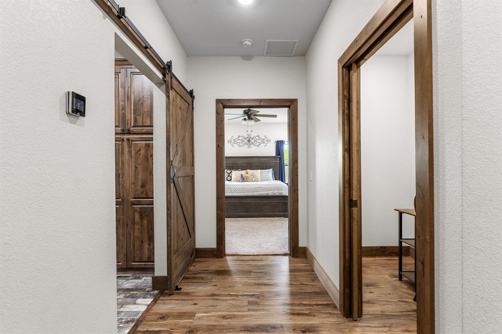 515 Sales Road Windthorst, TX 76389 - Photo 12 of 34 a view of a hallway with wooden floor and a bathroom