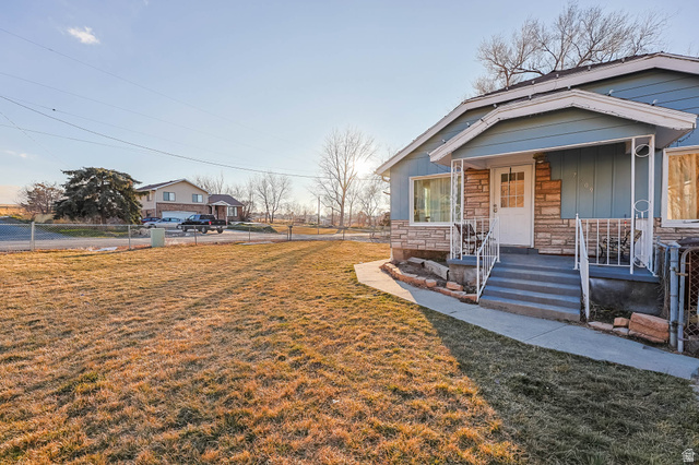 View of front facade with covered porch, stone siding, and board and batten siding