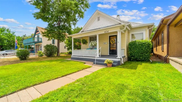a view of an house with backyard space and a tree