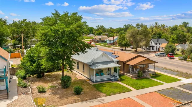 an aerial view of a house with swimming pool garden and trees