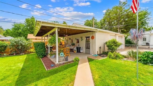 a view of a chair and table in backyard of the house