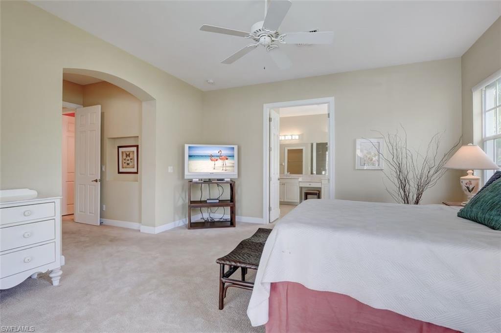 16092 Parque Lane Naples, FL 34110 - Photo 25 of 35 a bedroom with a bed and a chandelier