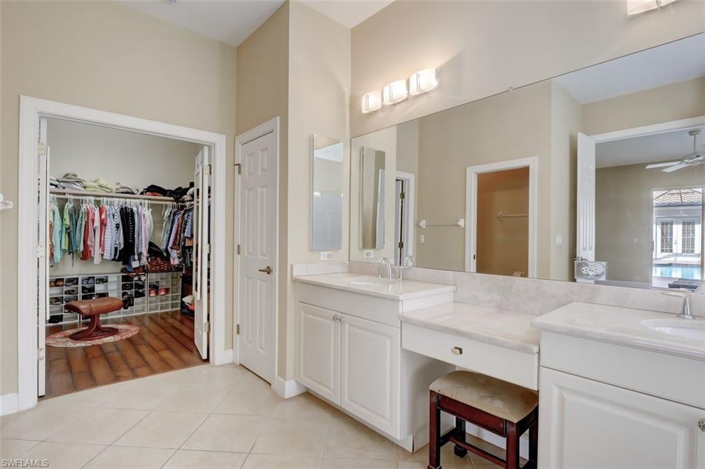 16092 Parque Lane Naples, FL 34110 - Photo 28 of 35 a spacious en suite bathroom with a double vanity sink tub and mirror