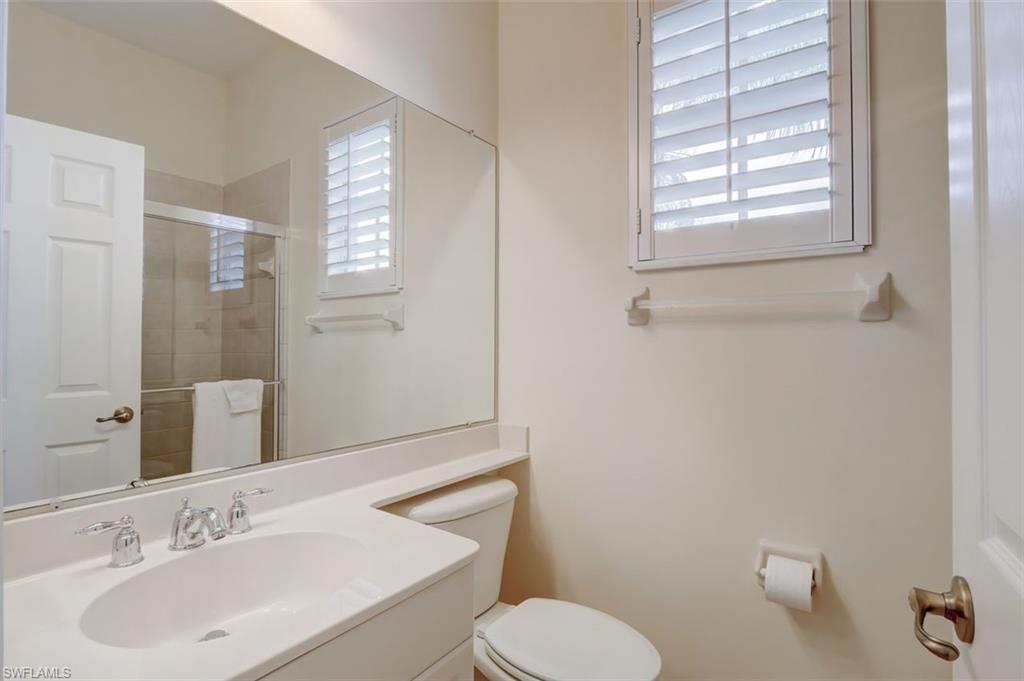16092 Parque Lane Naples, FL 34110 - Photo 33 of 35 a bathroom with a toilet sink and mirror