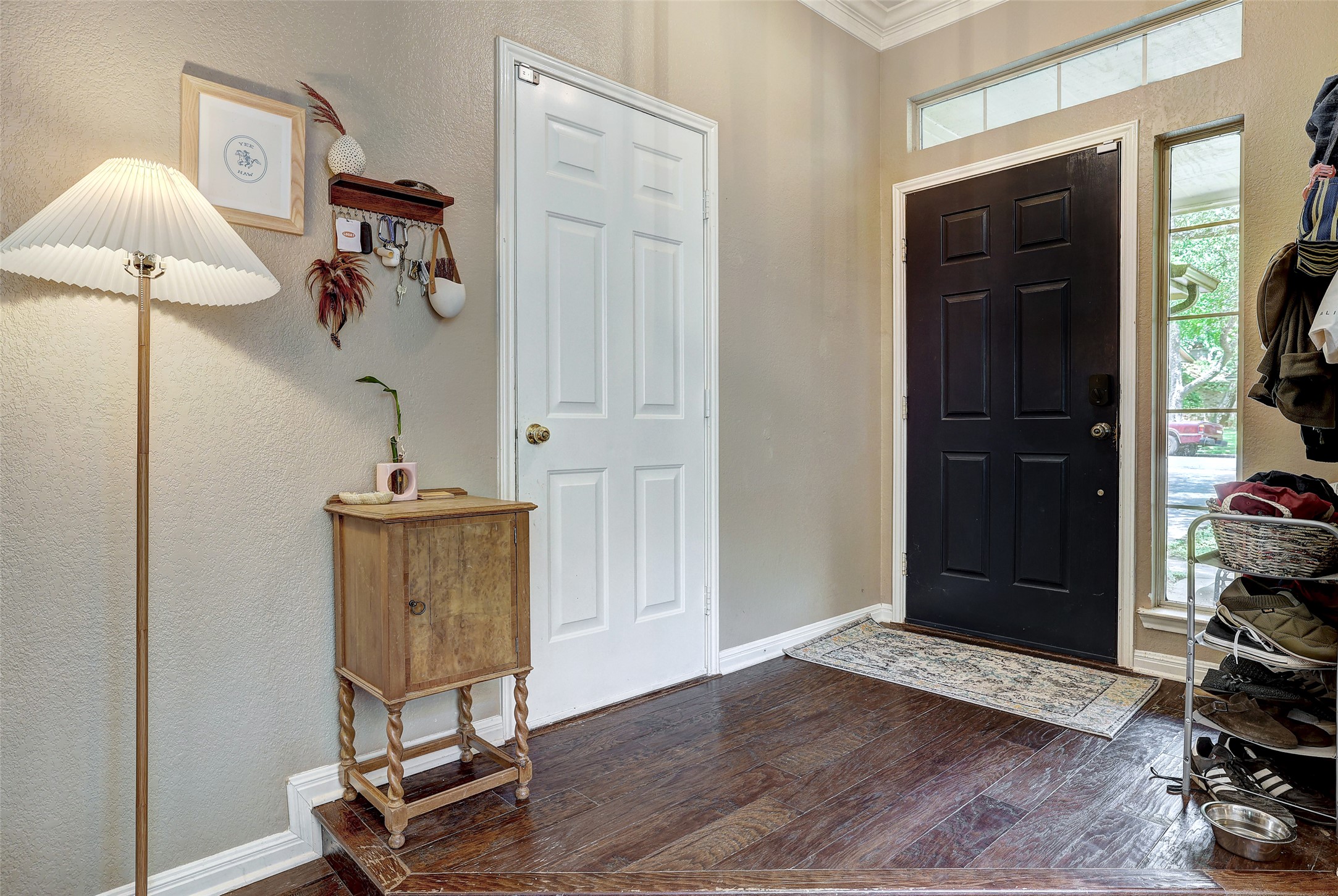 5907 Shanghai Pierce Road Austin, TX 78749 - Photo 5 of 29 Foyer featuring dark wood-style flooring, ornamental molding, and a textured wall