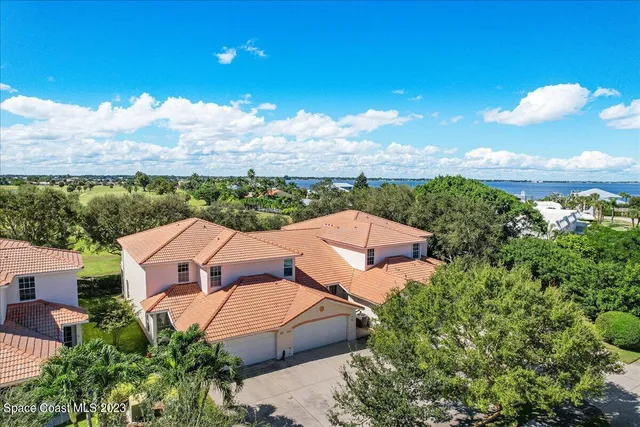 an aerial view of a house with a yard and lake view