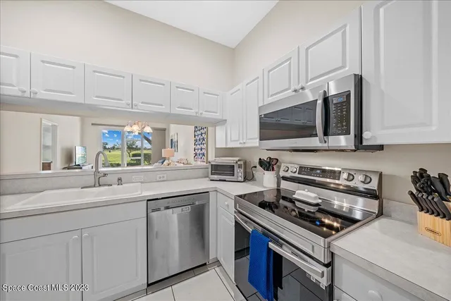 a kitchen with stainless steel appliances white cabinets and a stove top oven