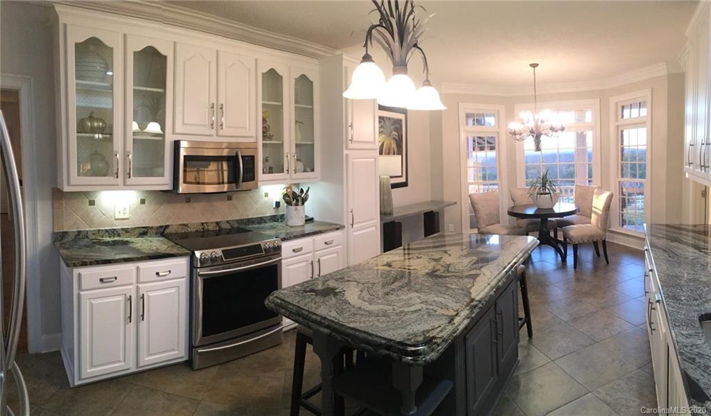 3215 Startown Road Lincolnton, NC 28092 - Photo 16 of 39 a kitchen with stainless steel appliances granite countertop a stove refrigerator and a dining table with wooden floor