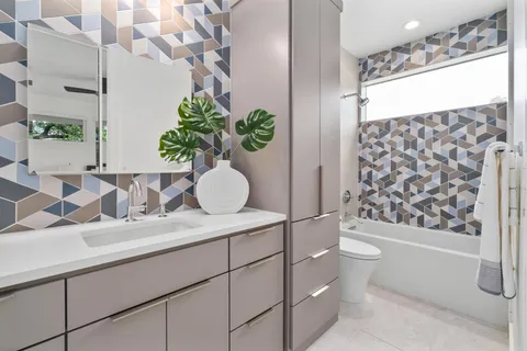 a bathroom with a granite countertop sink a toilet and shower