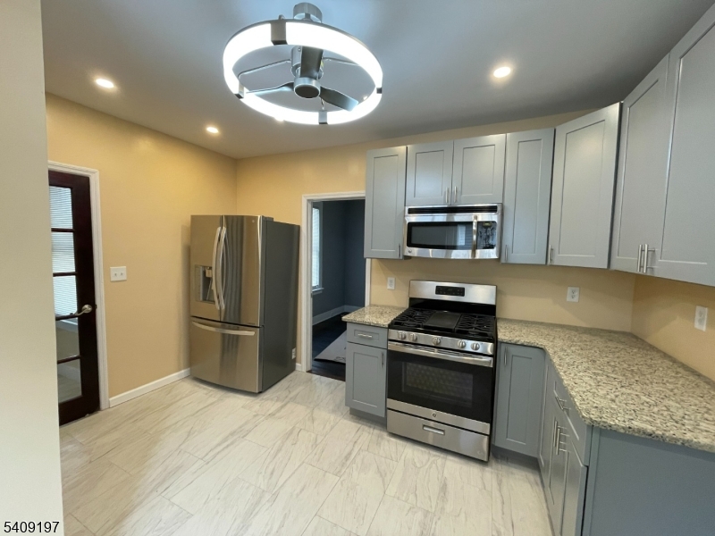 25 Bayview Avenue Newark, NJ 07112 - Photo 7 of 15 a kitchen with granite countertop a refrigerator and a stove top oven