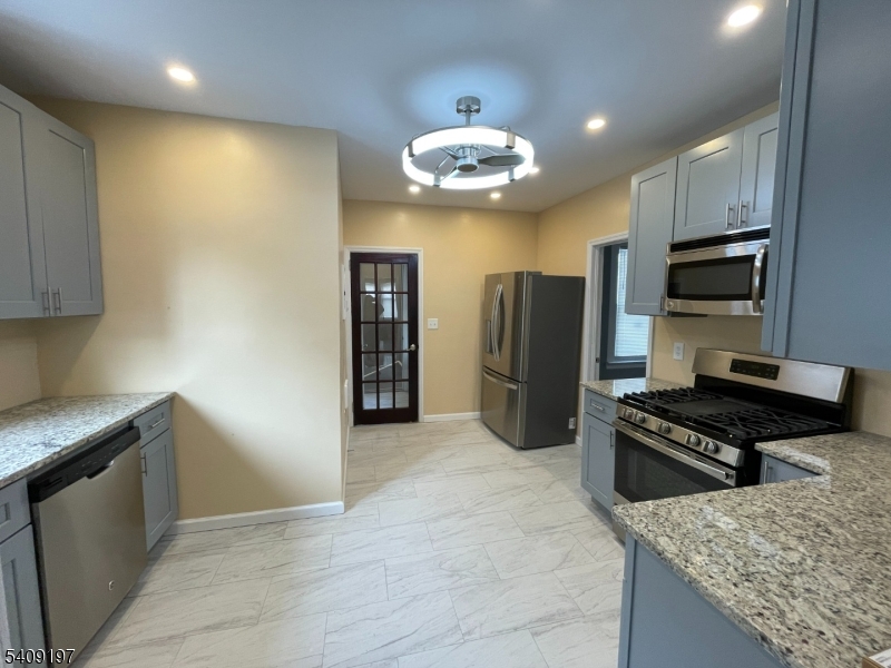 25 Bayview Avenue Newark, NJ 07112 - Photo 8 of 15 a kitchen with stainless steel appliances granite countertop a refrigerator and a stove top oven
