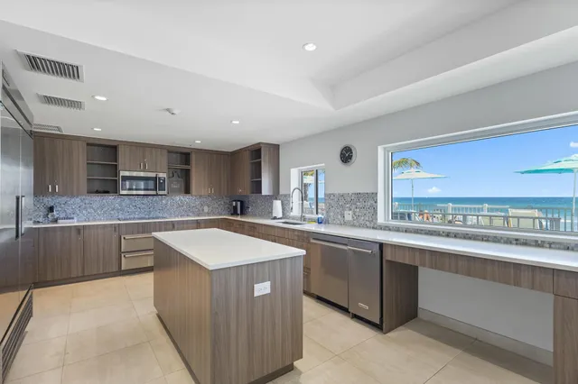 a kitchen with stainless steel appliances granite countertop a sink counter space cabinets and a large window