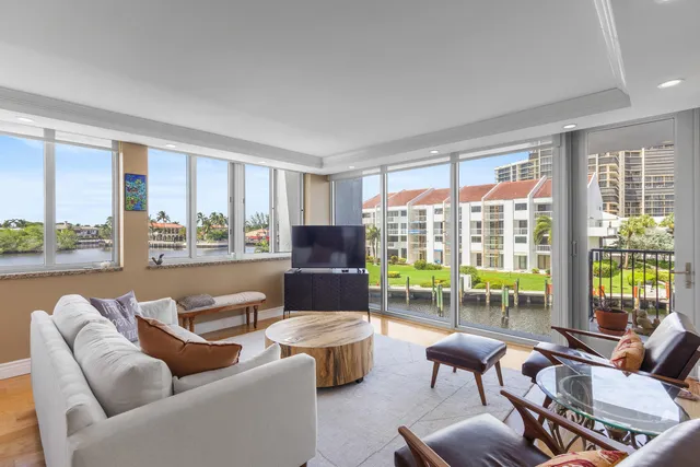 a living room with furniture and floor to ceiling windows